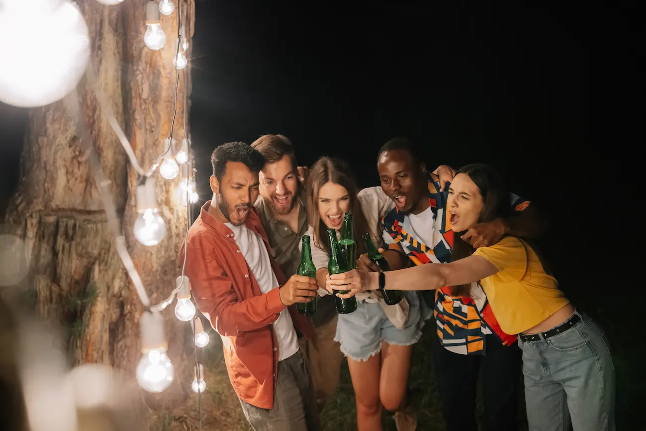 Group of friends celebrating together with drinks at an outdoor party
