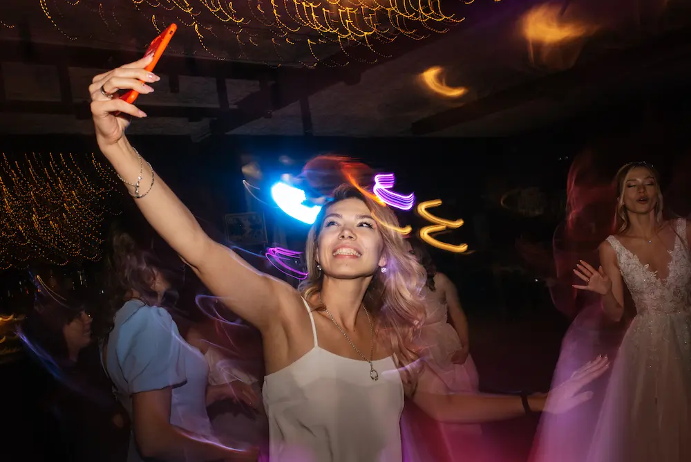 Wedding guest taking a selfie on the dance floor
